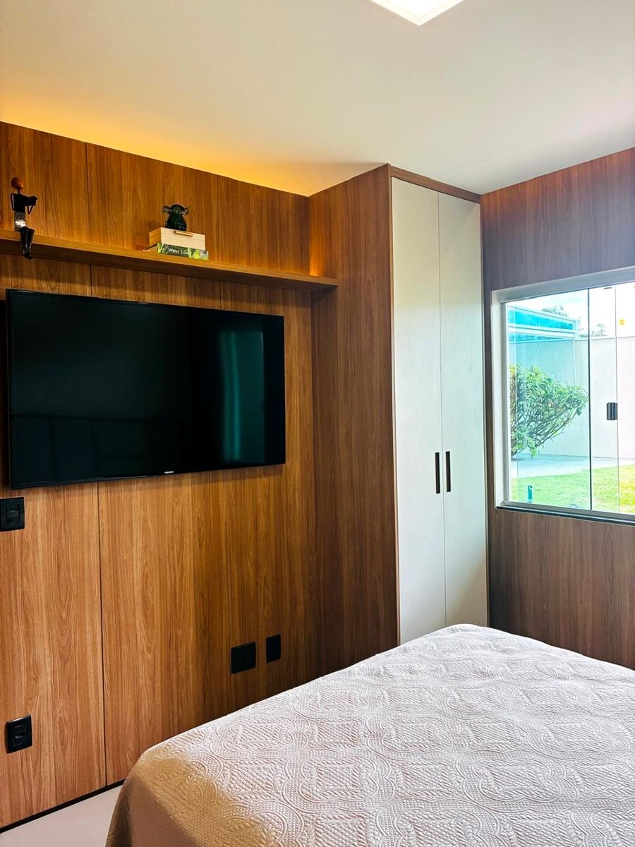 Painel ripado com TV, prateleira iluminada em LED e porta embutida
